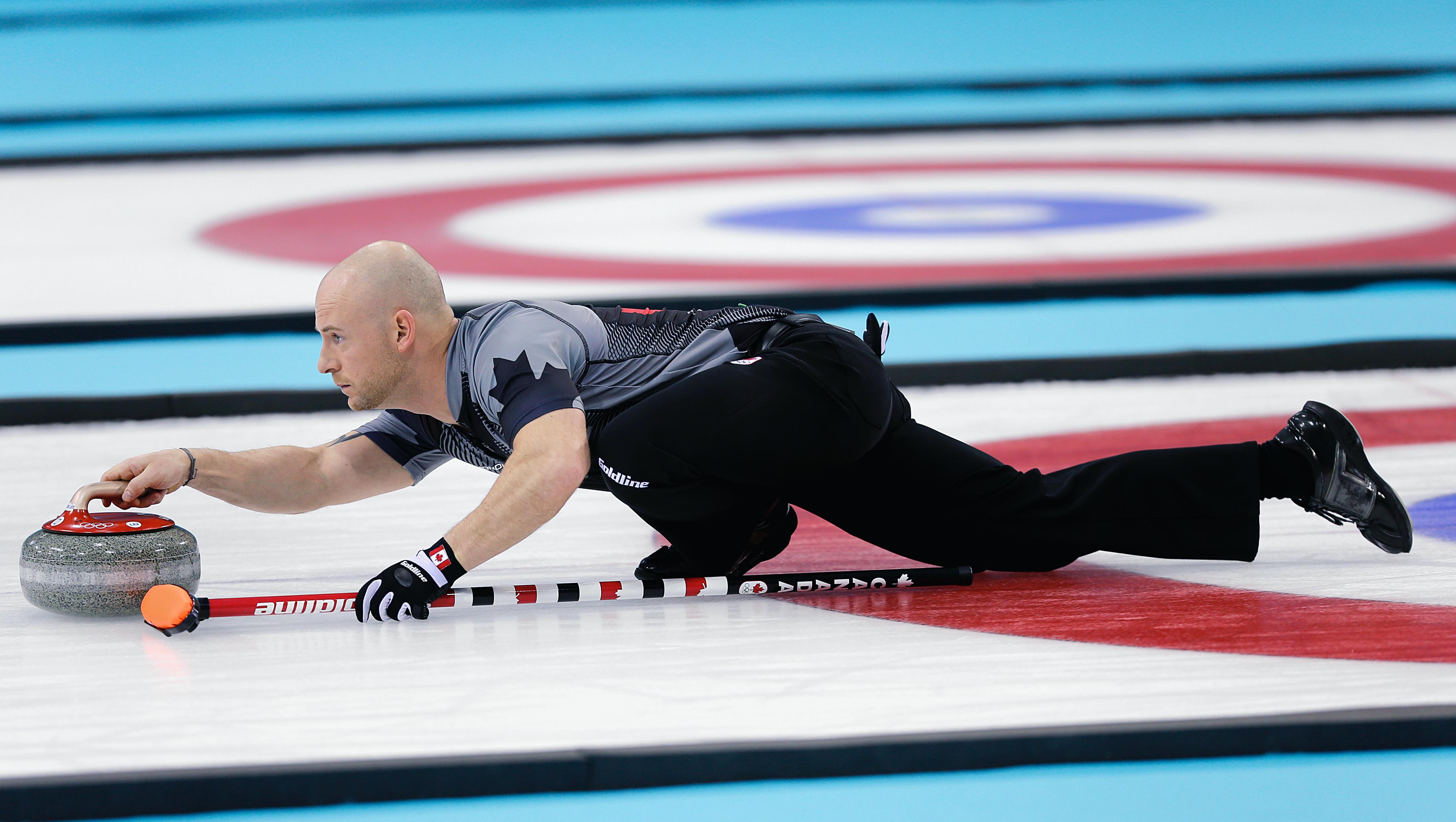 Utøver som er på curlingisen og skal sende avgårde en curlingstein.
