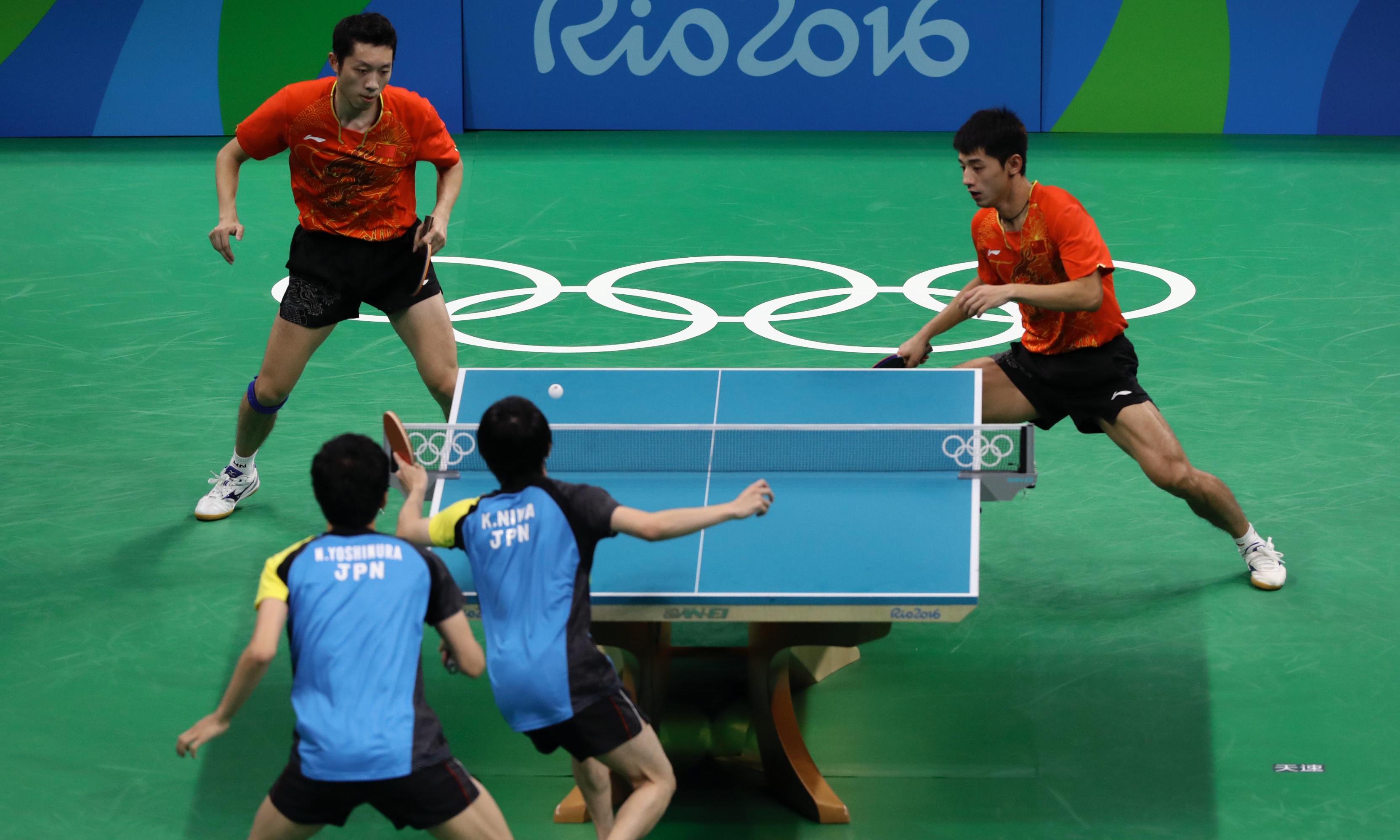 Bordtenniskamp med to spillere på hvert lag hvor en slår ballen over nettet.